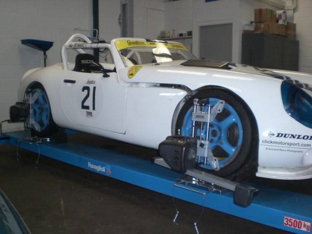 A white race car on the alignment ramp