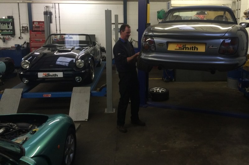A technician at work under TVRs raised on the workshop lifts
